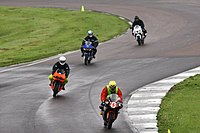 Motorcycle riders passing through the John Cooper Esses, taking part in a circuit track day Mallory Park Trackday.jpg