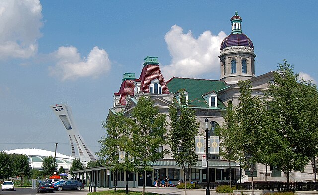 Marché Maisonneuve, a major farmer's market, with the statue La Fermière by Alfred Laliberté in the foreground and the Olympic Stadium in the backgrou