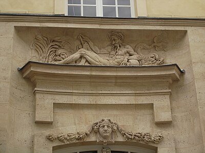 Bas-relief d'un « fleuve » et mascaron ornant la façade.