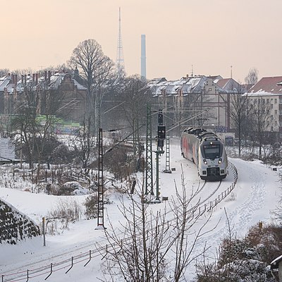 Suspended rail construction side between Leipzig Stötteritz and Leipzig Anger-Crottendorf after snowfall. A Class 442 train passes by.