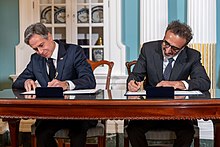 Tent Partnership for Refugees founder Hamdi Ulukaya (right) and US Secretary of State Antony Blinken sign a memorandum of understanding for a public-private partnership in 2022 Secretary Blinken Participates in a Memorandum of Understanding Signing Ceremony With the Tent Partnership for Refugees (52560051244).jpg