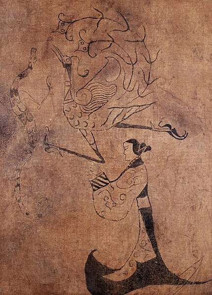 A phoenix (top) and dragon (left), Silk Painting of a Human Figure with Phoenix and Dragon, Silk painting unearthed from a Chu tomb.