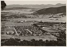 The platform of Civic Centre Station just visible in the foreground of the Sydney Building (1930s) The view from Mount Ainslie, Canberra, 1930s.jpg