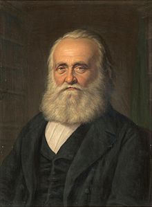 Фронтальный портрет Титуса Тоблера, бородатого, смотрящего прямо вперед.