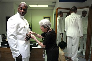 US Navy 080714-N-9818V-018 Explosive Ordnance Disposal 1st Class Tyrone Logan, left, 2008 U.S. Fleet Forces Command Sea Sailor of the Year is fitted for a uniform.jpg