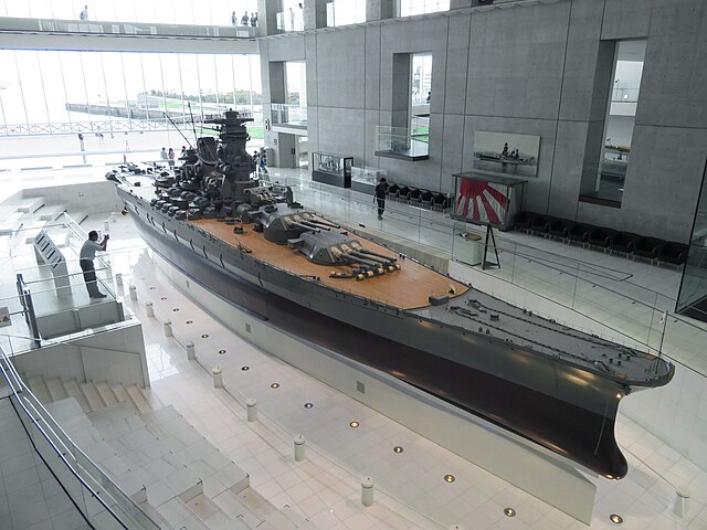 Three quarter view of a very large model of a battleship in an open gallery
