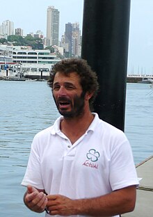 Busto, três quartos dos lados, barbudo, em um porto.  Camisa pólo flocada branca "Real".