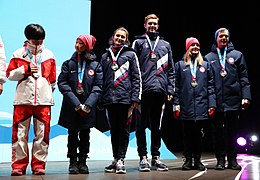 Tyutyunina/Shustitskiy (center) on the team podium at the 2020 Winter Youth Olympics