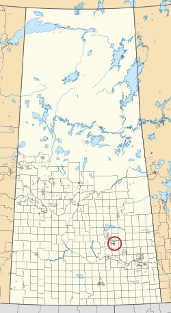 Mapa provincie Saskatchewan zobrazující 297 venkovských obcí a stovky malých indických rezerv. Jeden je zvýrazněn červeným kruhem.