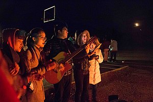 Christian people singing at a camp fire.JPG