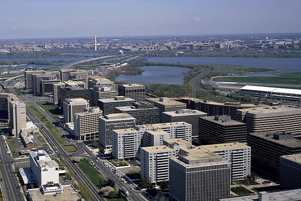 An aerial view of Crystal City (foreground) with I-395 crossing the Potomac River and the Jefferson Memorial and Washington Monument (background) in t