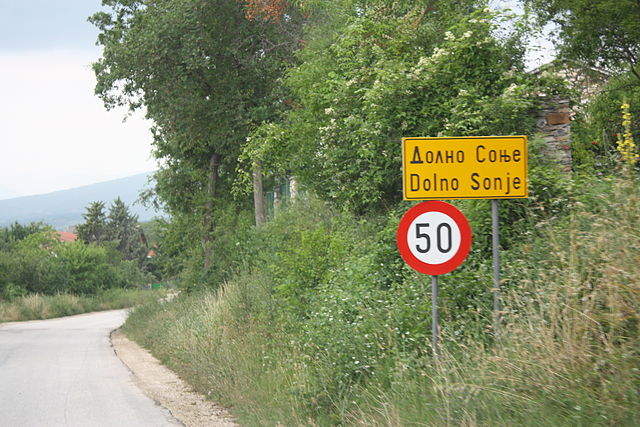 Road sign to Dolno Sonje in Macedonian Cyrillic (above) with romanization (below)