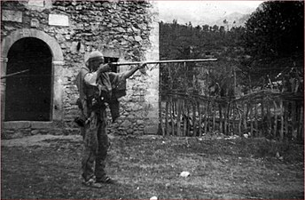 Old Said of the Nikaj tribe, inspecting his flint lock gun, a karajfile, Albania.