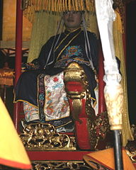 A man playing as the role of the emperor, wearing traditional clothing for the ritual.