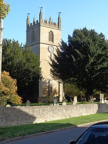 Photograph of St John The Baptist, Fladbury, taken from Church Street showing the church tower behind the church wall.