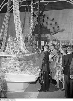 Fotothek df roe-neg 0006514 029 Besucher der Herbstmesse 1953 an einer Glasvitrine mit Stoffbahnen sowie Stoffba