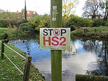 "Stop HS2" signs are frequently erected by opposition groups in areas close to the planned HS2 route Geograph-4267224-Stop HS2 sign next to the duck pond, Little Missenden.jpg