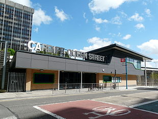 A modern building with lettering made out of reflective material on topː Cardiff Queen Street