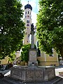 Wolfratshausener Marienbrunnen mit dem Kirchturm von St. Andreas im Hintergrund