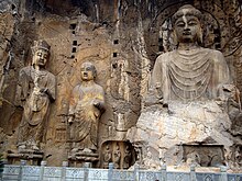 Massive Tang dynasty statues of a bodhisattva Guanyin, an arhat Kshitigarbha, and Vairocana Buddha. Longmen Grottoes, Henan province, China Longmen-lu-she-na-1.jpg