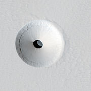HiRISE image of a 35 m wide lava tube skylight surrounded by a collapse pit on Pavonis Mons
