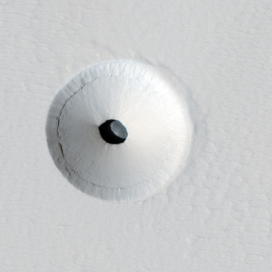 Cropped version of a HiRISE image of a lava tube skylight entrance on the Martian volcano Pavonis Mons.