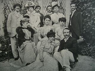 1901年以前。後3列目左からエドモン・ド・ポリニャック公、(ルーマニアボヤールの)ブランコヴァン公夫人、マルセル・プルースト、アンナ・ド･ノアイユの兄弟(ボヤールの)コンスタンタン・ブランコヴアヌ公ら。2列目中央がポリニャック公夫人ウィナレッタ・シンガー、右がアンナ・ド・ノアイユ。最前列の女性はアンナ・ド・ノアイユの2歳下の妹エレーヌ(エリザベットの弟アレクサンドル・カラマン＝シメイ伯夫人, 1878-1929年)