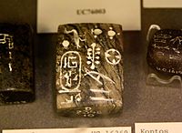 Serpentine weight of 10 daric, inscribed for Taharqa during the 25th Dynasty Serpentine weight of 10 daric. Inscribed for Taharqa in the midst of Sais. 25th Dynasty. From Egypt, probably from Nesaft. The Petrie Museum of Egyptian Archaeology, London.jpg