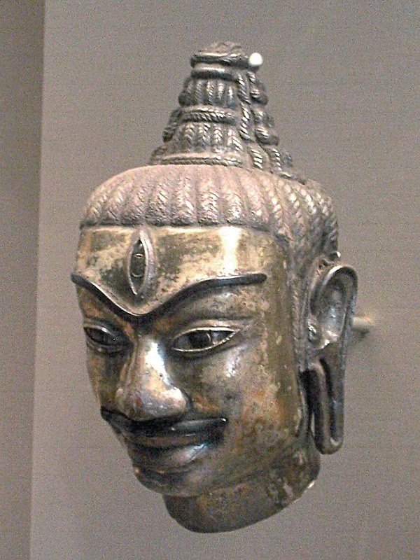 This Cham head of Shiva was made of electrum around 800. It decorated a kosa, or metal sleeve fitted to a liṅgam. One can recognise Shiva by the tall 