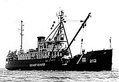 Historic photograph of the USCGC Fir, a heavy-duty vessel with a large crane boom rising from its fore section.