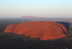 Uluru (Ayers Rock) i förgrundenmed Kata Tjuta (The Olgas) i bakgrunden