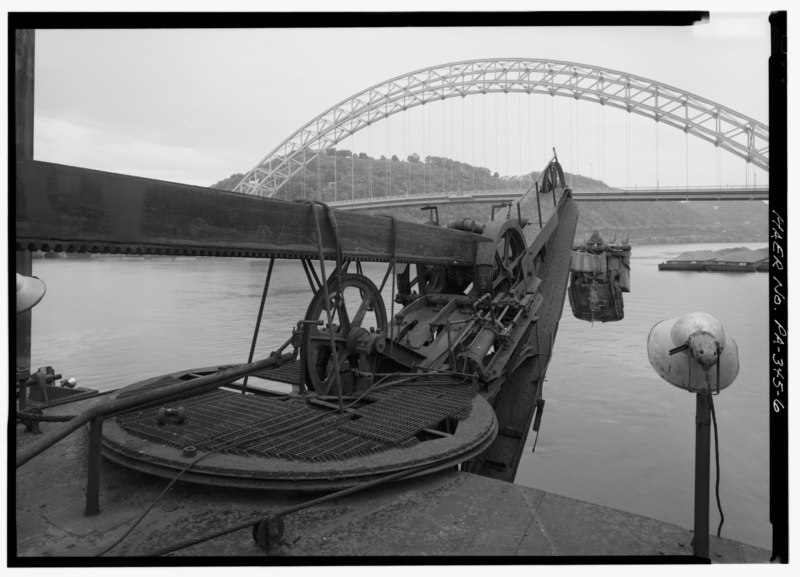 File:VIEW OF DIPPER STICK, WITH BUCKET. BULL WHEEL WITH SWINGER CABLE IN FOREFRONT. POINT SHIVE AT END OF CRANE. THE WHEELS ARE THE BRAKE DRUMS ON THE ENDS OF THE SHAFT. - Dredge HAER PA,2-PITBU.V,4-6.tif