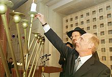 President Putin lighting a Hannukah Menorah with Russia's Chief Rabbi Berel Lazar. Judaism is officially designated as one of Russia's four state-religions. Vladimir Putin 21 December 2000-2.jpg