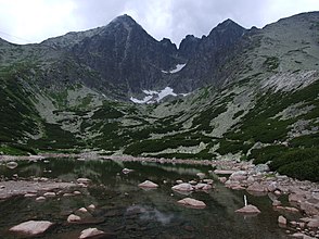 Die Skalnatá dolina zwischen den Gipfeln von Lomnický štít und Kežmarský štít, mit dem Bergsee Skalnaté pleso im Vordergrund und sichtbaren Terrassenstufen Lievikový kotol und Cmiter im Hintergrund