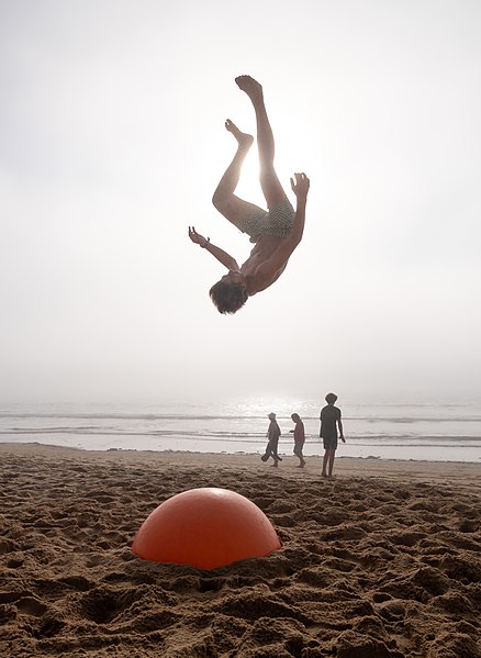 File:Acrobatic flip using an exercise ball buried in the sand, Praia América, Galicia, Spain (PPL1-Corrected) 2 julesvernex2.jpg