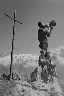 Modlitwa w Alpach w środkowej Szwajcarii.  Krzyż wskazuje miejsce rytualnego, górskiego pastwiska nad Engelberg, Obwalden około 1940 roku.