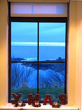 A (blue) view of the sea from window decorarted for Christmas