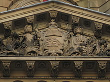 An early version of the City of Sydney coat of arms on the portico facade of the Town Hall. Coat of arms of Sydney at Town Hall.jpg