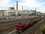 日立駅構内に入る貨物列車。後ろの工場は日立セメント工場（2009年1月）