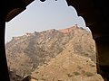 Another view of Jaigarh Fort framed by a window in Amber Fort