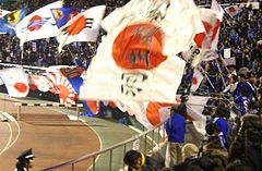 Japanese footballing fans wave a Rising Sun Flag during a Japan vs. Bosnia and Herzegovina match in January 2008.