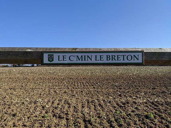 Trinity road name signs are white with green text. This sign is in Jèrriais, Jersey's traditional language.