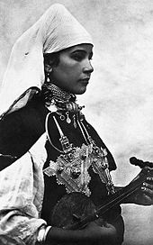 A Berber musician wearing two large triangular brooches in southern Morocco (early 20th century photo) Musicienne aux bijoux.jpg