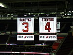 The retired numbers of Ken Daneyko (no. 3) and Scott Stevens (no. 4) hang in the rafters of the Prudential Center. New Jersey Devils' Retired Numbers.jpg