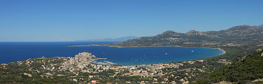 Vue panoramique sur la ville et la baie de Calvi. Au loin, les montagnes du Cap Corse.