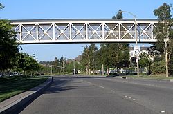 A typical stretch of Newhall Ranch Road, with a pedestrian bridge over the roadway. Paseo on Newhall Ranch Road.jpg