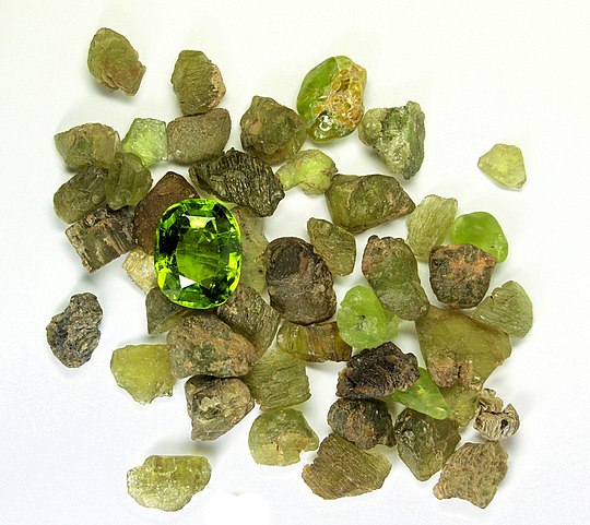 Peridot (Mg, Fe)2SiO4 in the rough form and a cut and polished gem.
