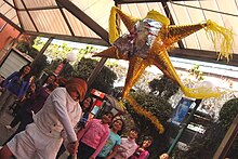 Breaking a pinata at a Posada Rompiendo la pinata.JPG