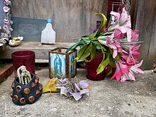 Objects left inside the Cross Bones garden Virgin Mary Shrine on the Western Wall of Cross Bones Graveyard (II).jpg