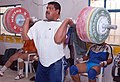 A strong man lifting a very heavy weight.